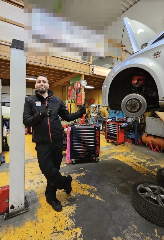 Monteur van RPM Garage in de werkplaats, met een auto op de brug